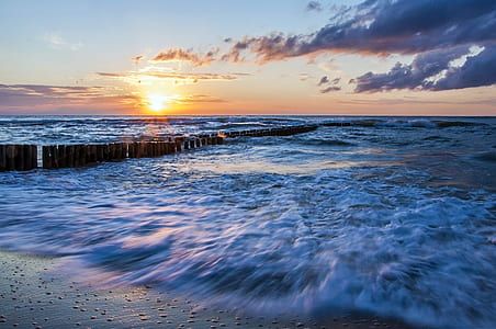 sea waves crashing on shore during golden hour thumbnail