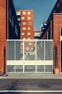 white metal gate between brown concrete buildings under blue sky at daytime thumbnail