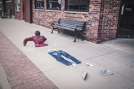 blue denim jeans, pair of blue low-top sneakers and white dress shirt on grey concrete floor near red bricks during daytime thumbnail