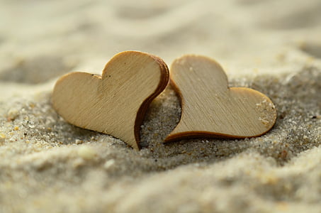 two heart shape wooden decoration on sand thumbnail