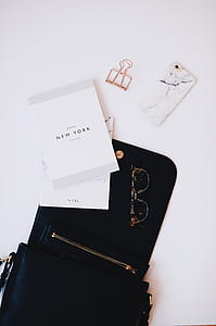 gold-colored framed eyeglasses on black leather bag thumbnail
