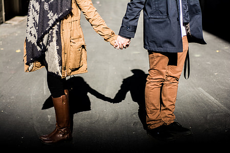 man and woman holding hands standing on street thumbnail