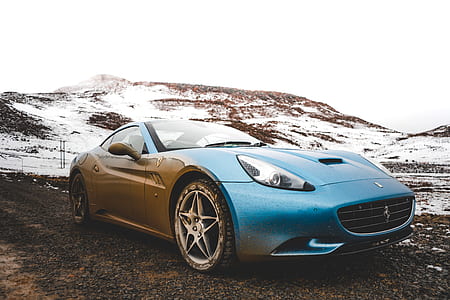 blue Ferrari California running on soil during daytime thumbnail