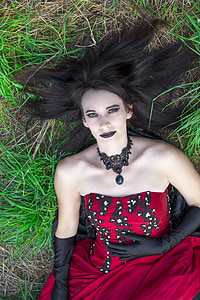 woman wearing red and black strapless dress lying on groun thumbnail