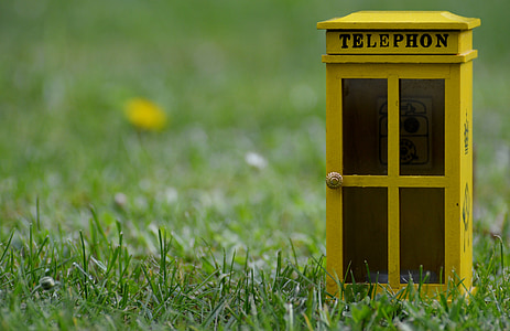 yellow telephone booth on green grass thumbnail