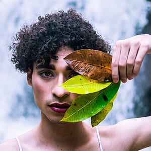person using four leaves to cover left side of his face thumbnail