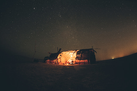 man inside the hut with lamp during nighttime thumbnail