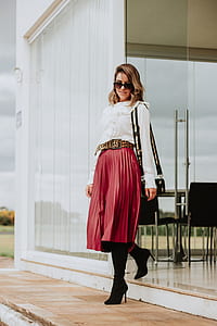 woman wearing white blouse and red skirt walking on brown concrete floor thumbnail