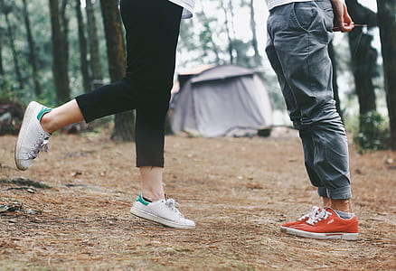 two person standing near gray tent surrounded by trees thumbnail