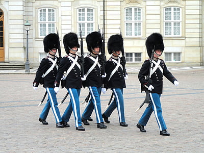 officers marching in front of grey building thumbnail