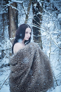 woman wearing brown fur coat standing near snow covered ground and trees thumbnail