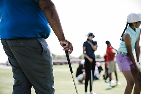 Person Holding Golf Club Near Girl and Woman thumbnail
