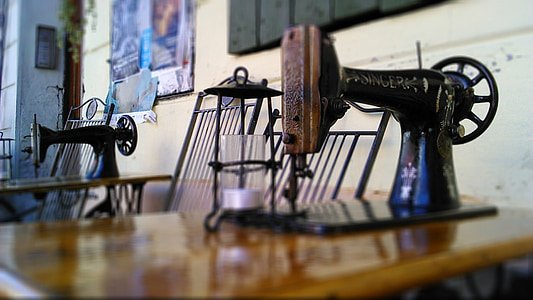 black and brown Singer treadle sewing machine near white wall inside room thumbnail