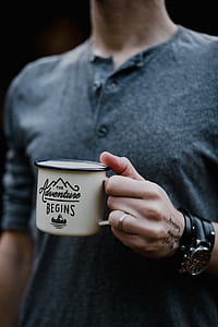 man wearing gray henley long-sleeved top holding white ceramic mug thumbnail