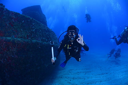 underwater photography of person wearing diving attire thumbnail