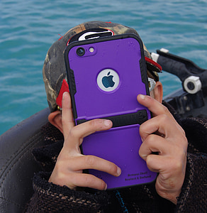 man holds silver iPhone 7 with purple case thumbnail