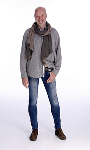 smiling man wearing brown scarf, gray shirt and blue denim jeans thumbnail