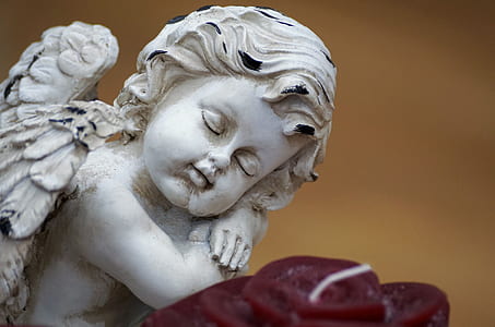 close-up photography sleeping angel figurine thumbnail