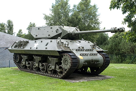 green battle tank parked over green grass ground near trees thumbnail