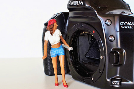 girl doll in front of black Minolta camera thumbnail