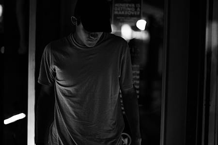 grayscale photography of man standing near wall thumbnail