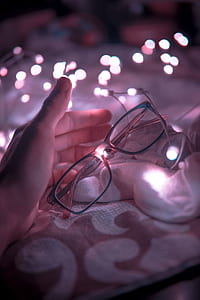 Black Frame Eyeglasses and White String Lights in White Textile thumbnail