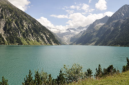 body of water surrounded by mountains during daytime thumbnail