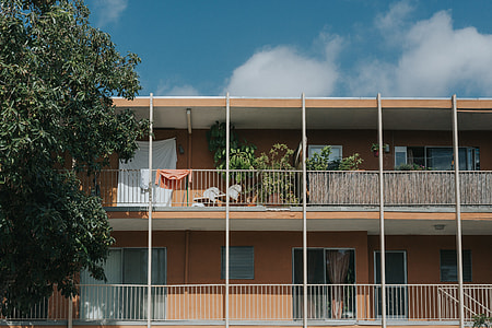 brown concrete painted building under white cloudy skies thumbnail