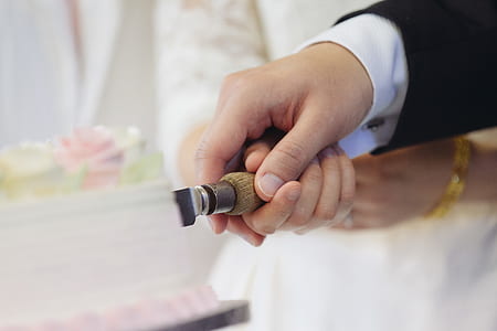 bride and groom cutting together a wedding cake thumbnail