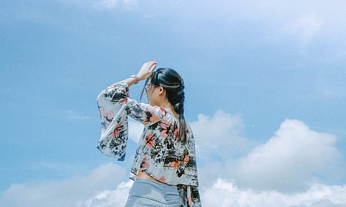 woman standing while raising left arm thumbnail