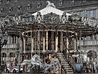 horse carousel in front of concrete building thumbnail