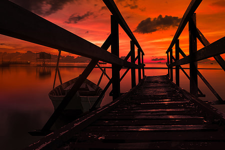 Stunning summer sunset on the coast with boat in water thumbnail