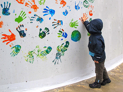child standing beside wall while touching it thumbnail