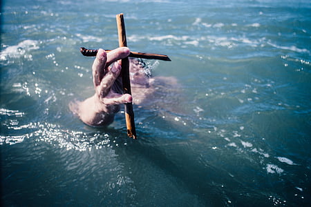drowning person holding wooden cross thumbnail