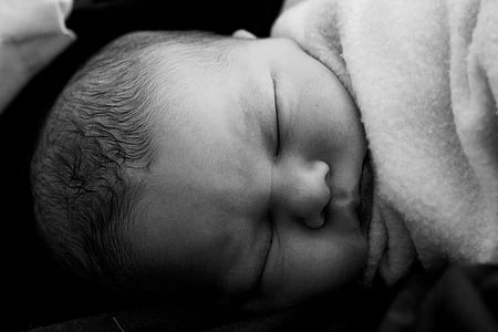 grayscale photography of baby lying on bed thumbnail