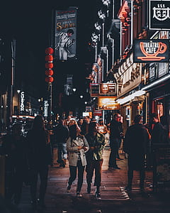 people in sidewalk beside shops thumbnail