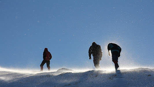 low angle of three men climbing snowy mountain thumbnail