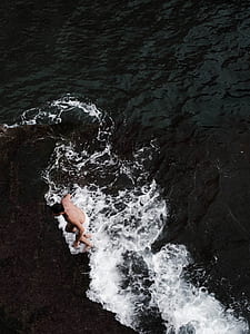 aerial photography of man standing in sea thumbnail