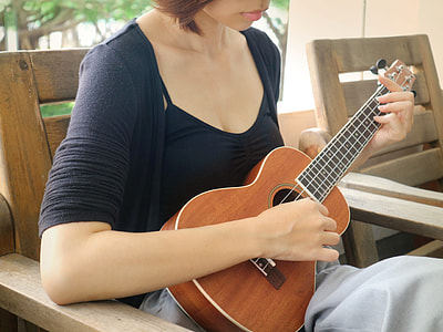 woman sitting on chair while playing ukulele thumbnail