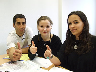 two women and one man sitting beside table thumbnail