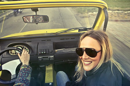 Woman In Black Aviator Sunglasses Sitting On Car's Passenger Seat thumbnail