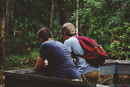 two men leaning on gray wooden fence thumbnail