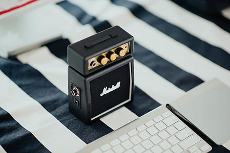 guitar pedal beside apple magic keyboard on white and black striped textile thumbnail