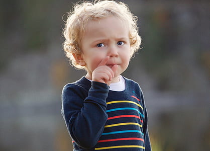 boy wearing black, blue, and yellow striped long-sleeved top thumbnail