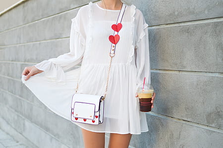 woman holding plastic cup standing near wall thumbnail