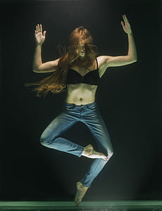 woman wearing black bra and blue jeans standing with one foot thumbnail
