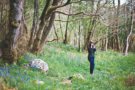 woman standing on grees near trees during dayrime thumbnail