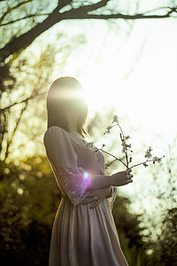woman in nude-colored 3/4-sleeved dress holding white flowers thumbnail
