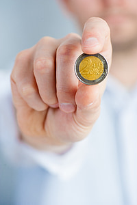 person holding round silver-colored coin thumbnail