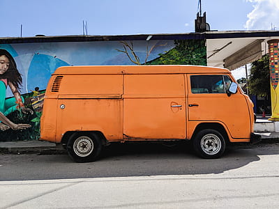orange van beside concrete house thumbnail